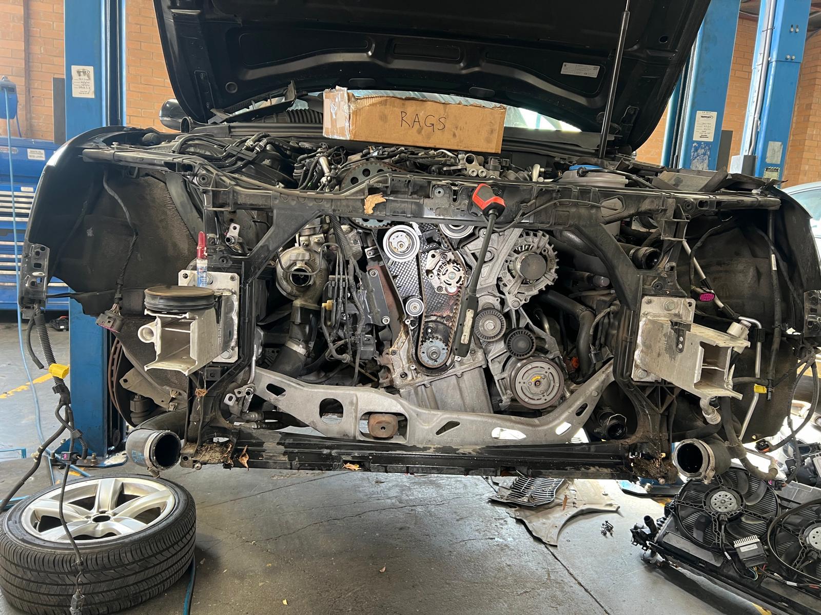 SUV on the hoist with its front end stripped for a timing belt job